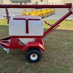 A red and white ATV Off-Road Auger Wagon with a large plastic hopper, adjustable auger arm, and 1000 LB capacity is parked on grass near an industrial building, ready for towing.